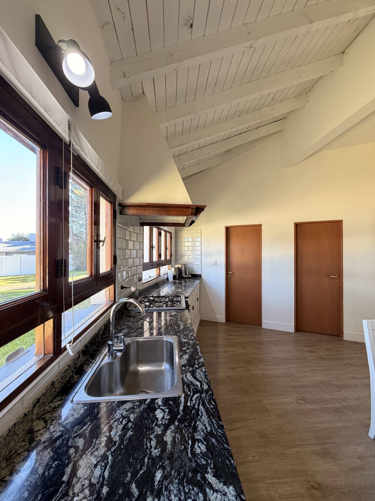 Cocina con mesada de granito y ventanales al parque